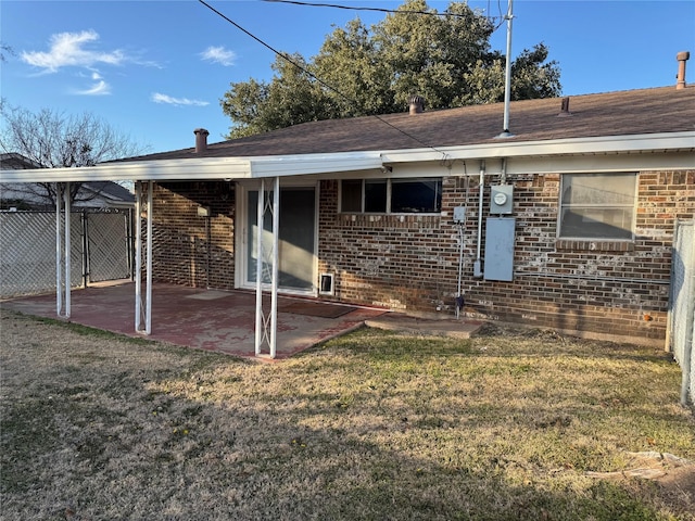 1916 11th St, Mineral Wells, TX 76067 - back of property with a patio area, brick siding, and roof with shingles