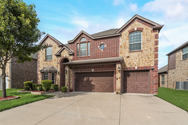 1220 Glendon Dr, Forney, TX 75126 - view of front of house with an attached garage, stone siding, concrete driveway, brick siding, and a front lawn