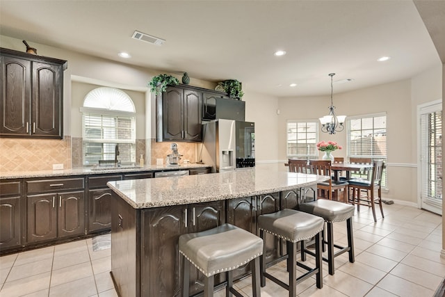 1220 Glendon Dr, Forney, TX 75126 - kitchen featuring stainless steel appliances, a kitchen island, light tile patterned flooring, recessed lighting, and a kitchen breakfast bar