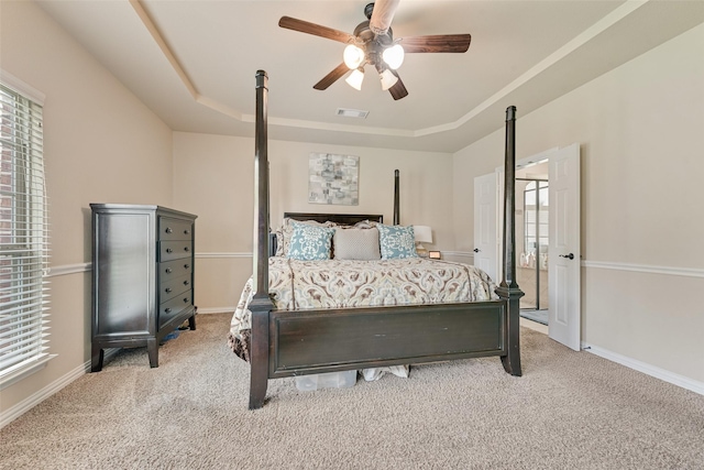 1220 Glendon Dr, Forney, TX 75126 - bedroom featuring a tray ceiling, light carpet, multiple windows, and a ceiling fan