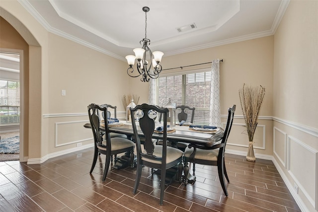 1220 Glendon Dr, Forney, TX 75126 - dining room with a chandelier, a raised ceiling, arched walkways, dark wood-type flooring, and ornamental molding