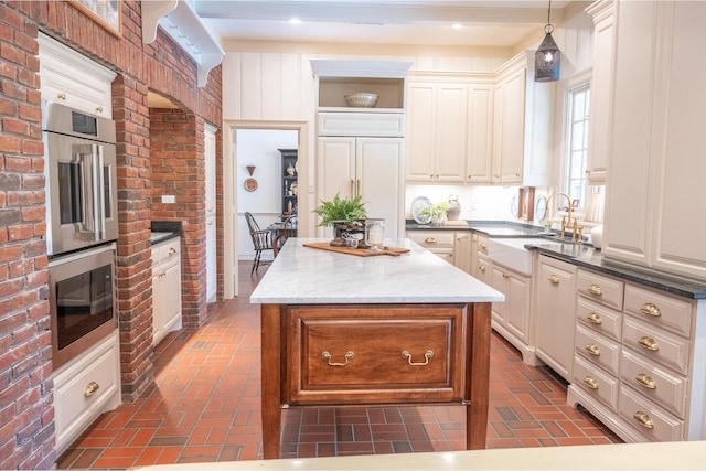 5906 Tiffany Ct, Arlington, TX 76016 - kitchen featuring brick flooring, a center island, decorative light fixtures, double oven, and brick wall