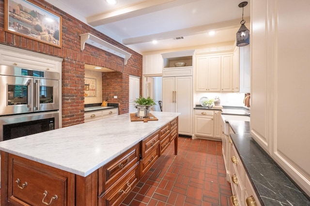 5906 Tiffany Ct, Arlington, TX 76016 - kitchen featuring brick floors, a center island, beam ceiling, light stone countertops, and double oven