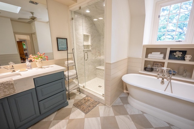 5906 Tiffany Ct, Arlington, TX 76016 - bathroom featuring a freestanding bath, a wainscoted wall, a shower stall, vanity, and a skylight