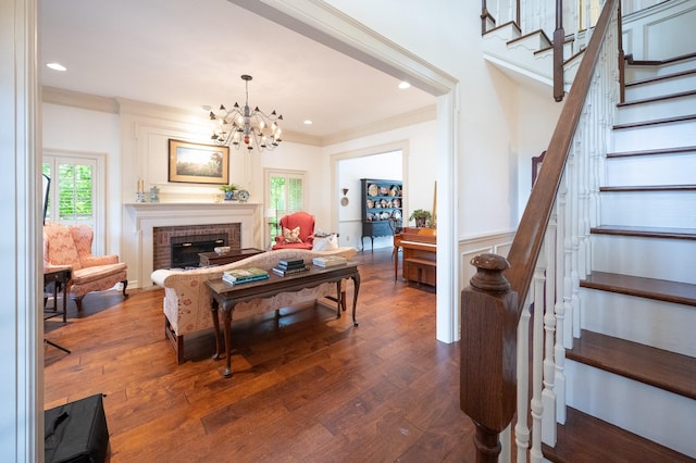 5906 Tiffany Ct, Arlington, TX 76016 - living area featuring stairs, dark wood-type flooring, ornamental molding, a chandelier, and a brick fireplace