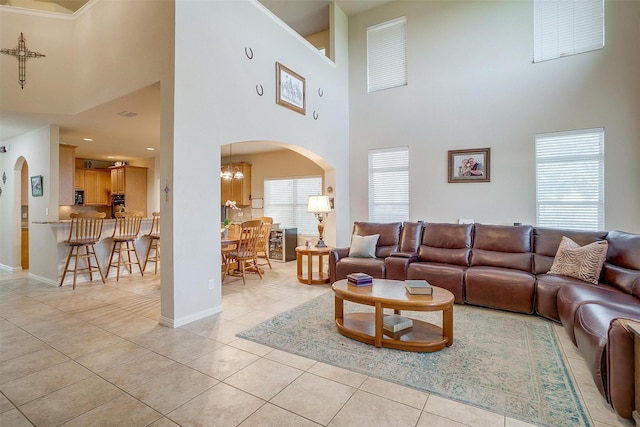 2536 Glenn Ranch Dr, Burleson, TX 76028 - living area with a high ceiling, arched walkways, light tile patterned floors, and a chandelier
