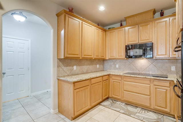 2536 Glenn Ranch Dr, Burleson, TX 76028 - kitchen featuring black microwave, light brown cabinetry, arched walkways, light tile patterned floors, and backsplash