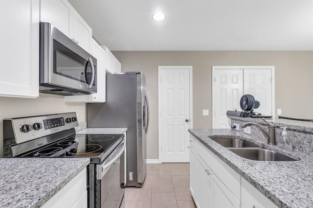 2017 Langston St, Fort Worth, TX 76105 - kitchen featuring stainless steel appliances, white cabinetry, light tile patterned flooring, light stone countertops, and recessed lighting
