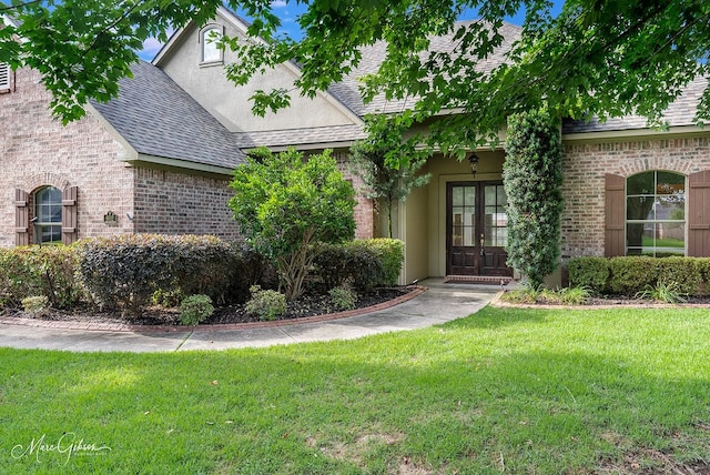 902 Blair Xing, Bossier City, LA 71111 - view of front of home featuring french doors, brick siding, a front lawn, roof with shingles, and stucco siding