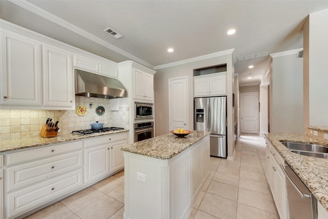 4263 Veneto Dr, Frisco, TX 75033 - kitchen featuring stainless steel appliances, exhaust hood, tasteful backsplash, white cabinetry, and a center island
