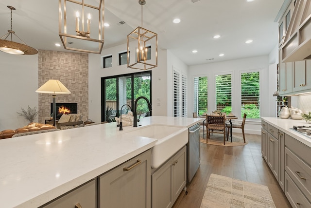 1704 Cannon St, Van Alstyne, TX 75495 - kitchen featuring stainless steel appliances, recessed lighting, light countertops, gray cabinets, and a large fireplace