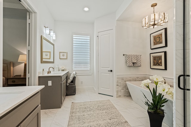 1704 Cannon St, Van Alstyne, TX 75495 - bathroom featuring marble finish floors, two vanities, a chandelier, a freestanding bath, and recessed lighting