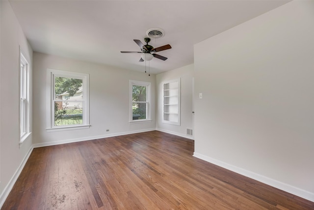 103 E 14th St, Joshua, TX 76058 - spare room featuring built in shelves, wood finished floors, and a ceiling fan