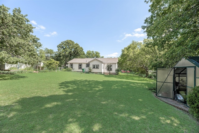 103 E 14th St, Joshua, TX 76058 - view of green lawn with an outdoor structure and a greenhouse