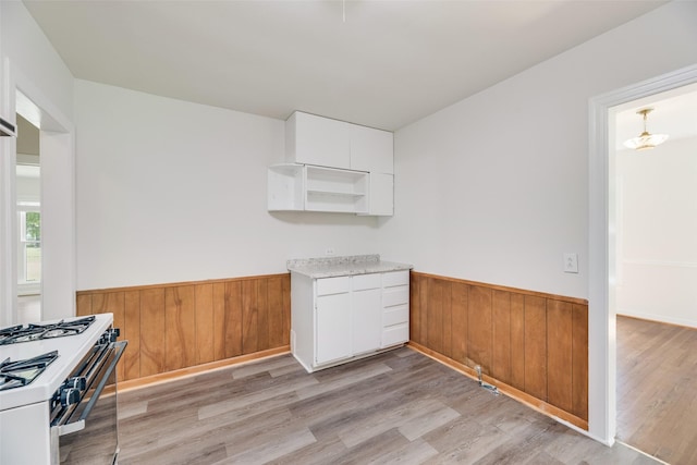 103 E 14th St, Joshua, TX 76058 - kitchen featuring wainscoting, open shelves, white cabinetry, white range with gas cooktop, and light wood-style floors