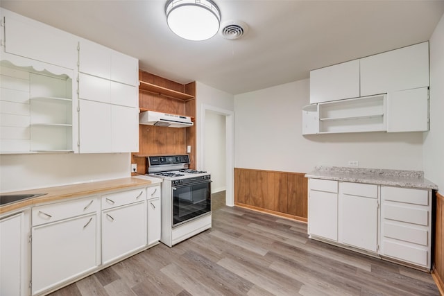 103 E 14th St, Joshua, TX 76058 - kitchen featuring open shelves, white gas range oven, under cabinet range hood, light wood-style flooring, and wainscoting
