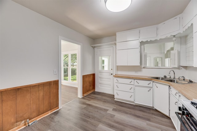 103 E 14th St, Joshua, TX 76058 - kitchen featuring wainscoting, light countertops, white cabinets, wood finished floors, and stove