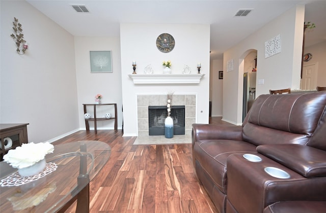 3209 Silver Point Ct, Mansfield, TX 76063 - living room with wood finished floors, arched walkways, and a tiled fireplace