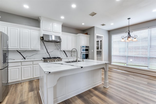 11722 Estacado Dr, Frisco, TX 75033 - kitchen with exhaust hood, appliances with stainless steel finishes, backsplash, light wood-style flooring, and recessed lighting
