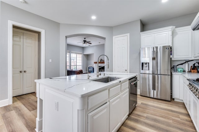 11722 Estacado Dr, Frisco, TX 75033 - kitchen with appliances with stainless steel finishes, an island with sink, arched walkways, recessed lighting, and a ceiling fan