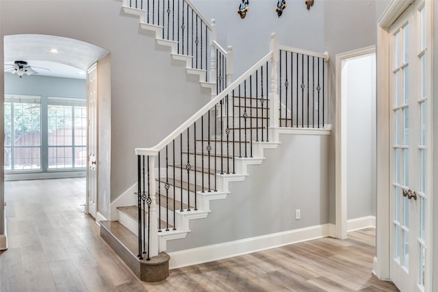 11722 Estacado Dr, Frisco, TX 75033 - stairs with arched walkways, wood finished floors, a ceiling fan, and french doors