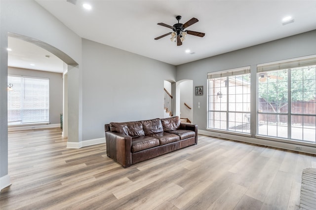 11722 Estacado Dr, Frisco, TX 75033 - living area with arched walkways, light wood finished floors, ceiling fan, plenty of natural light, and recessed lighting