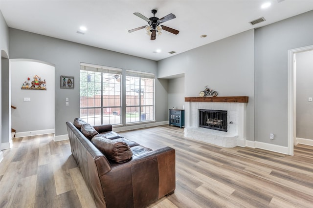 11722 Estacado Dr, Frisco, TX 75033 - living area with ceiling fan, light wood-type flooring, arched walkways, a brick fireplace, and recessed lighting