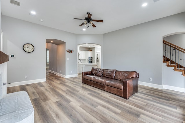 11722 Estacado Dr, Frisco, TX 75033 - living area featuring arched walkways, a ceiling fan, light wood finished floors, stairs, and recessed lighting