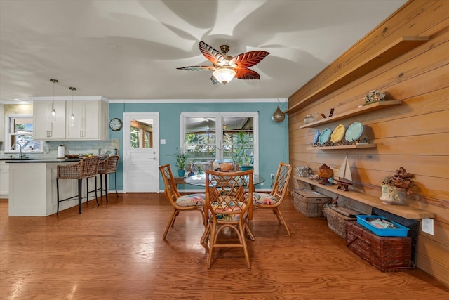 2113 Trinity Dr, Waco, TX 76710 - dining room featuring healthy amount of natural light, a ceiling fan, crown molding, wood finished floors, and wood walls