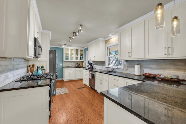 2113 Trinity Dr, Waco, TX 76710 - kitchen featuring stainless steel appliances, light wood-style flooring, white cabinets, decorative backsplash, and dark stone countertops