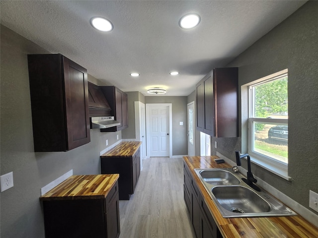 130 Jackson St N, Sulphur Springs, TX 75482 - kitchen with wood counters, light wood-style flooring, under cabinet range hood, a textured ceiling, and recessed lighting