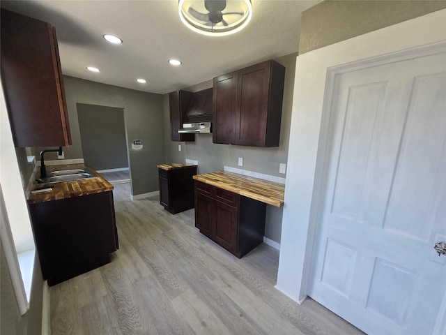130 Jackson St N, Sulphur Springs, TX 75482 - kitchen featuring under cabinet range hood, light wood-style floors, dark brown cabinets, built in desk, and recessed lighting