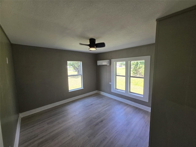 130 Jackson St N, Sulphur Springs, TX 75482 - spare room featuring a textured ceiling, wood finished floors, healthy amount of natural light, a wall unit AC, and ceiling fan