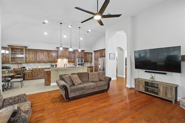 2428 Lilyfield Dr, Trophy Club, TX 76262 - living area featuring arched walkways, a ceiling fan, lofted ceiling, and wood finished floors