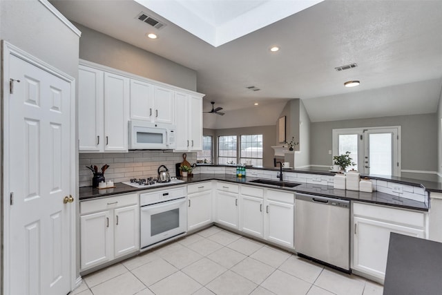 10715 Robincreek Ln, Frisco, TX 75035 - kitchen featuring white appliances, dark countertops, white cabinets, decorative backsplash, and recessed lighting