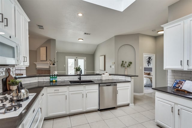 10715 Robincreek Ln, Frisco, TX 75035 - kitchen featuring white appliances, decorative backsplash, dark countertops, white cabinetry, and light tile patterned floors