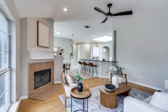 10715 Robincreek Ln, Frisco, TX 75035 - living area featuring ceiling fan, a tile fireplace, light wood-type flooring, and recessed lighting