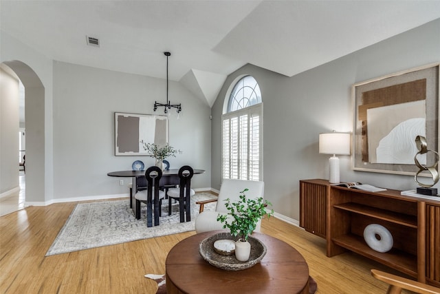 10715 Robincreek Ln, Frisco, TX 75035 - dining area featuring arched walkways, light wood finished floors, and vaulted ceiling