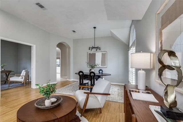 10715 Robincreek Ln, Frisco, TX 75035 - living room with arched walkways, light wood-style floors, and lofted ceiling