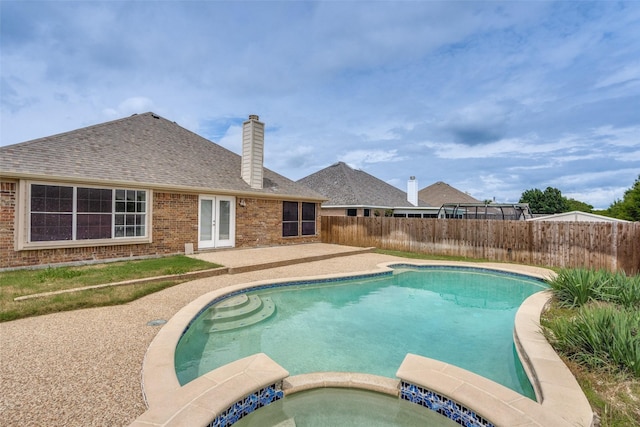 10715 Robincreek Ln, Frisco, TX 75035 - view of swimming pool with french doors, a fenced backyard, a pool with connected hot tub, and a patio