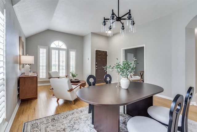 10715 Robincreek Ln, Frisco, TX 75035 - dining room with arched walkways, light wood-type flooring, and vaulted ceiling