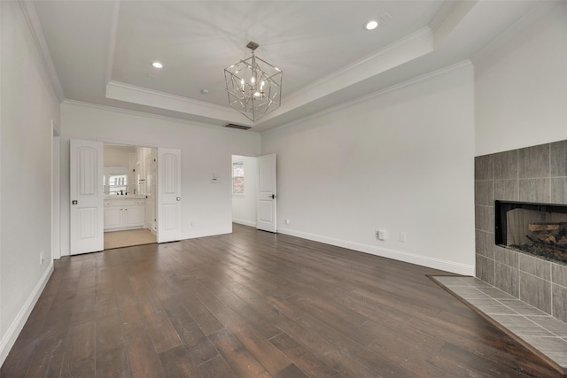 5513 Martel Ave, Dallas, TX 75206 - unfurnished living room featuring a raised ceiling, ornamental molding, a chandelier, dark wood-style flooring, and a tiled fireplace
