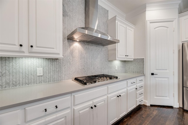 5513 Martel Ave, Dallas, TX 75206 - kitchen featuring wall chimney exhaust hood, stainless steel appliances, white cabinets, ornamental molding, and dark wood-style floors
