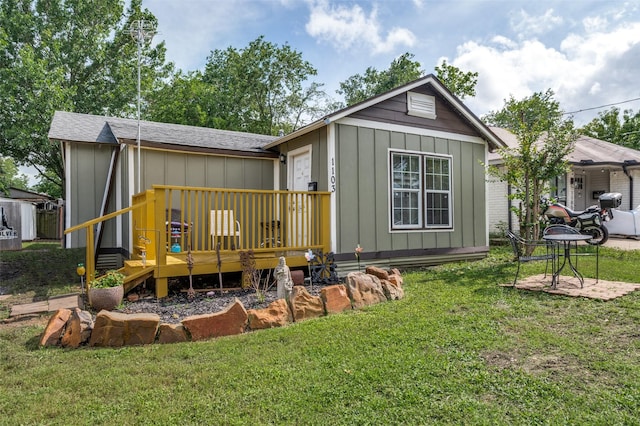 1103 1st Ave, Mckinney, TX 75069 - rear view of house with board and batten siding, a wooden deck, a yard, and a shingled roof