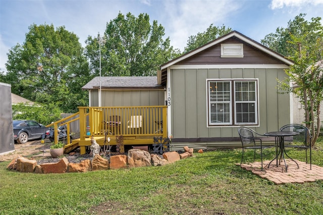 1103 1st Ave, Mckinney, TX 75069 - back of property with a deck, a lawn, and board and batten siding