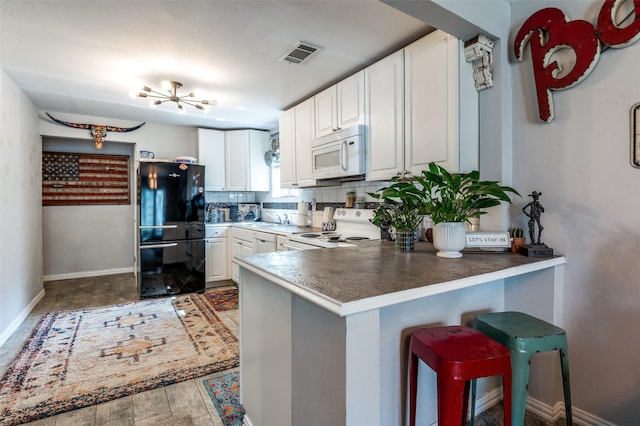 1103 1st Ave, Mckinney, TX 75069 - kitchen featuring white appliances, a peninsula, white cabinetry, and backsplash