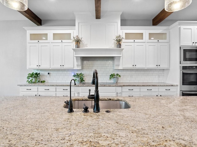 3628 S Fm 1655, Chico, TX 76431 - kitchen featuring beamed ceiling, appliances with stainless steel finishes, decorative backsplash, white cabinets, and glass insert cabinets