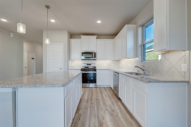 3104 Dixondale Dr, Fort Worth, TX 76108 - kitchen with appliances with stainless steel finishes, light wood-style flooring, a center island, white cabinets, and recessed lighting