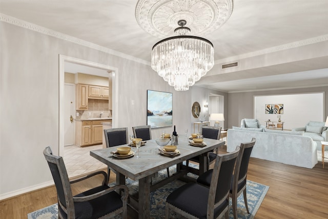 6325 Bandera Ave Unit C, Dallas, TX 75225 - dining space featuring light wood-type flooring, a chandelier, and crown molding