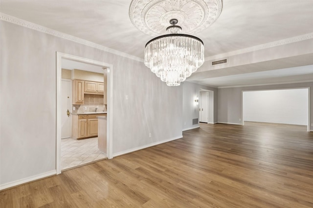 6325 Bandera Ave Unit C, Dallas, TX 75225 - spare room with a chandelier, light wood-type flooring, and ornamental molding